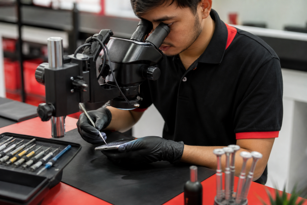 Teknisyen memeriksa telefon untuk repair charging port Kota Warisan